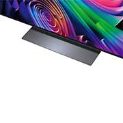 A LG OLED evo AI C6 está instalada na parede de uma sala de estar elegante, apresentando um design ultrafino com bordas estreitas, e exibe na tela uma paisagem urbana à beira do rio ao pôr do sol.