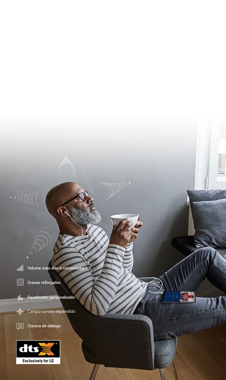 Homem bebendo café e ouvindo música nos fones de ouvido, sentado numa cadeira