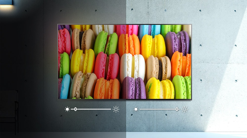 Uma tela, metade no escuro, metade na luz, mostra a imagem de macarons coloridos. O brilho é ajustado para cada lado.