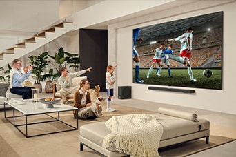 A family is gathered around their LG Ultra Big TV watching an exciting soccer match on the huge screen.