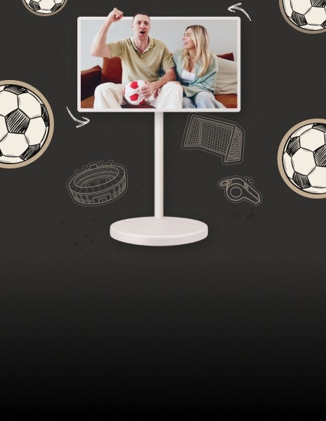 On the screen of the LG Smart Monitor Swing, a couple is seen on the sofa; the man is holding a plush soccer ball and cheering with a raised fist, while the woman smiles next to him.