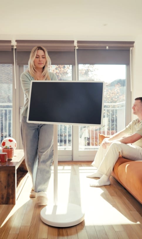 A woman moving a StanbyME 2 in a living room.