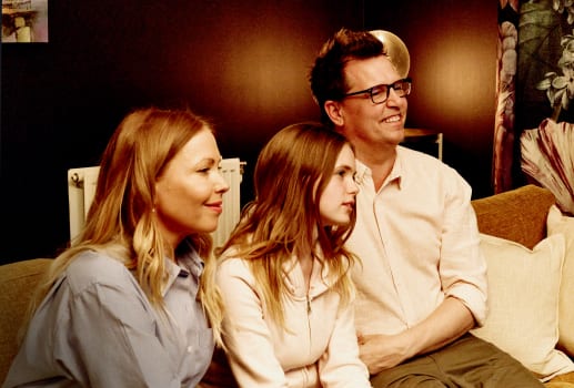 Family sitting on a sofa watching TV together