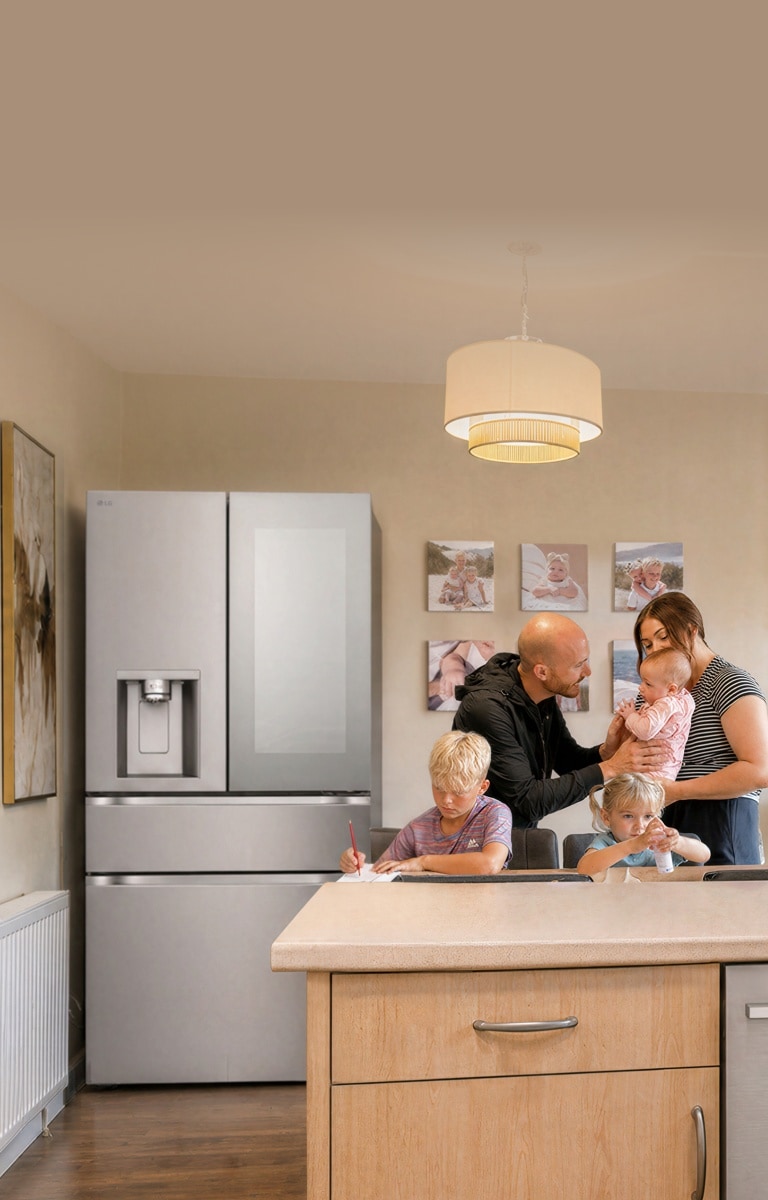 A family of four gathers in a modern kitchen behind a counter, with a stainless steel French-door refrigerator in the background.