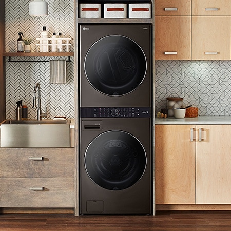 The LG WashTower WKGX201HBA in Black Steel, showcasing its space-saving single-unit design seamlessly integrated into a stylish, modern laundry room.