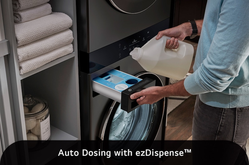 The LG WashTower WKEX300HBA in Black Steel, illustrating a user refilling the ezDispense™ Auto Dosing System, emphasizing the convenience of automatic detergent and softener dispensing.
