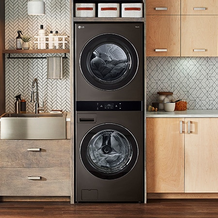 The LG WashTower WKEX300HBA in Black Steel, showcasing its space-saving single-unit design seamlessly integrated into a stylish, modern laundry room.