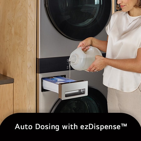 The LG WashTower SWWE50N3 in Stainless Steel, illustrating a user refilling the ezDispense™ Auto Dosing System, emphasizing the convenience of automatic detergent and softener dispensing.