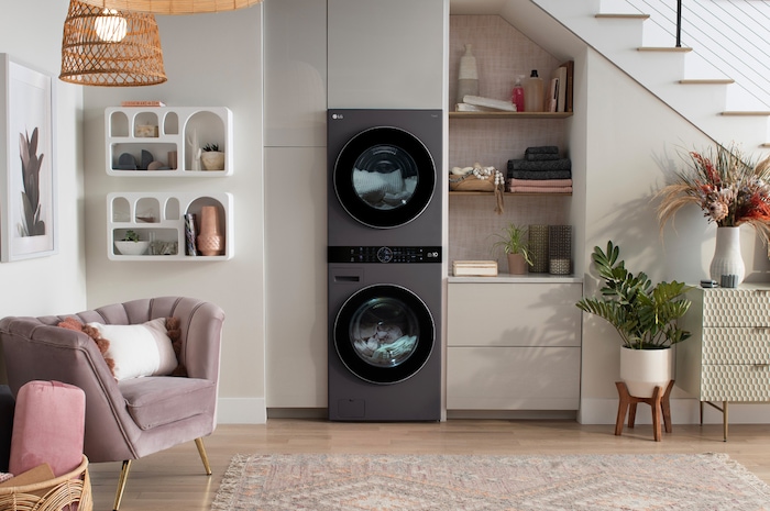 The LG WashTower WKHC252HBA in Black Steel, showcasing its premium, space-saving design and flexible installation, blending seamlessly into a modern living area under a staircase.