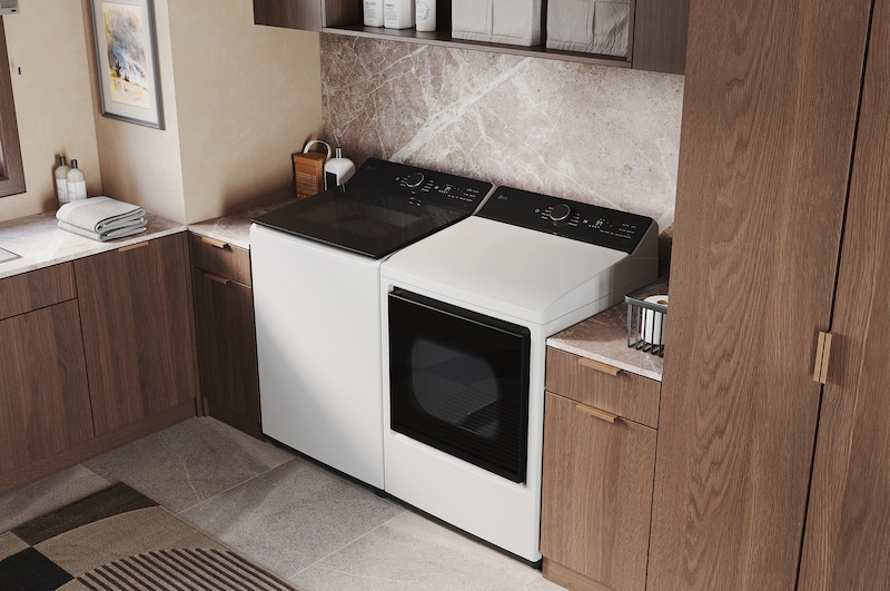 The LG Top Load Washer and Dryer set (DLE8400WE) in White, showcasing its premium, side-by-side design seamlessly integrated into a luxurious laundry room with marble and wood finishes.