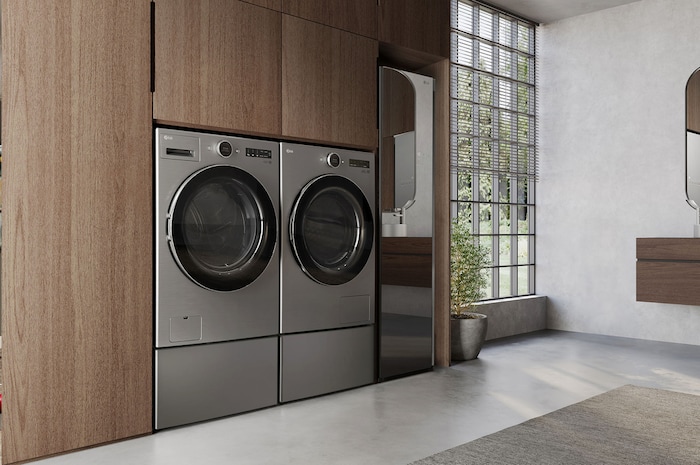 The LG Front Load Washer and Dryer set (DLHC5502V) in Graphite Steel, showcasing its premium aesthetic and seamless, flush integration into modern wood cabinetry.