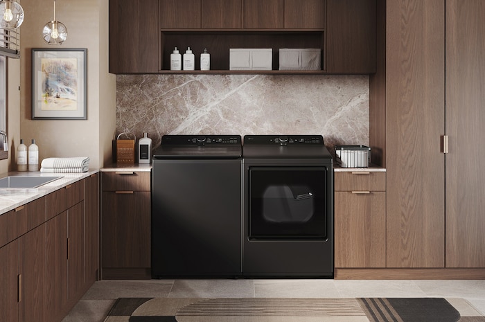 The LG Top Load Washer and Dryer set (DLE8400BE) in Black Steel, showcasing the flat-top design and premium finish integrated perfectly beneath the upper cabinetry.