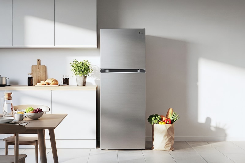 The stainless steel finish LG 24-inch 11 cu.ft. Top Freezer Refrigerator LT11C2000V, shown placed in a bright, modern kitchen setting.