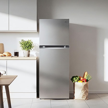 The stainless steel finish LG 24-inch 11 cu.ft. Top Freezer Refrigerator LT11C2000V, shown placed in a bright, modern kitchen setting.
