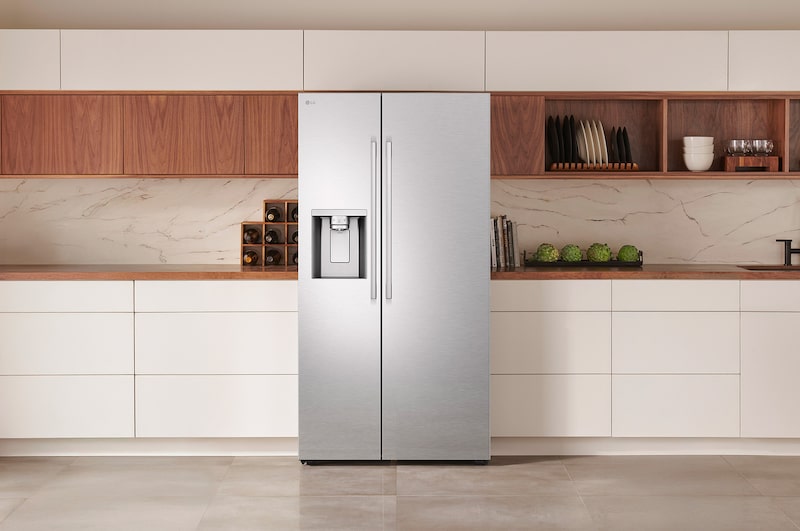 The stainless steel finish LG 36-inch 27 cu.ft. Smart Side-by-Side Refrigerator LL27T3530S with water dispenser, shown installed in a modern kitchen.