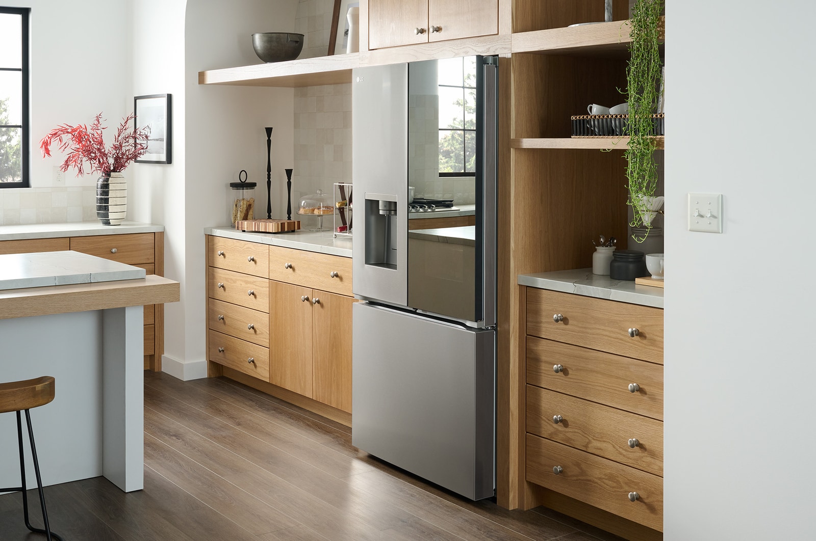 The stainless steel finish LG 36-inch 26 cu.ft. French Door Refrigerator LRYKC2606S, shown installed in a modern kitchen with light wood cabinets.