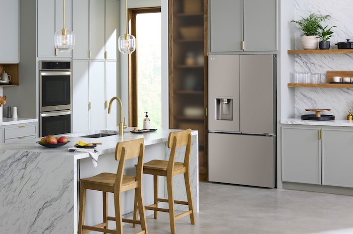 The stainless steel finish LG 36-inch 26 cu.ft. French Door Refrigerator LRYXC2606S, shown installed in a modern kitchen with light wood cabinets.
