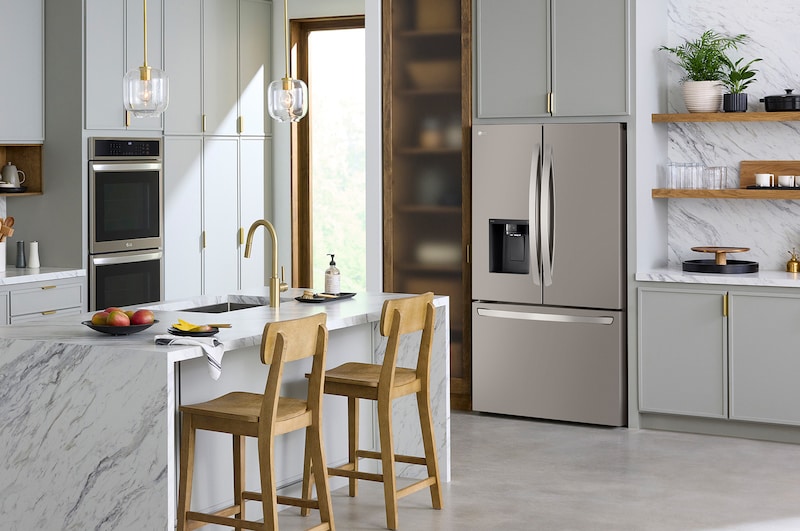 The PrintProof™ Stainless Steel LG 36-inch 26 cu.ft. French Door Refrigerator LRFXC2606S with ice & water dispenser, shown in a bright modern kitchen.