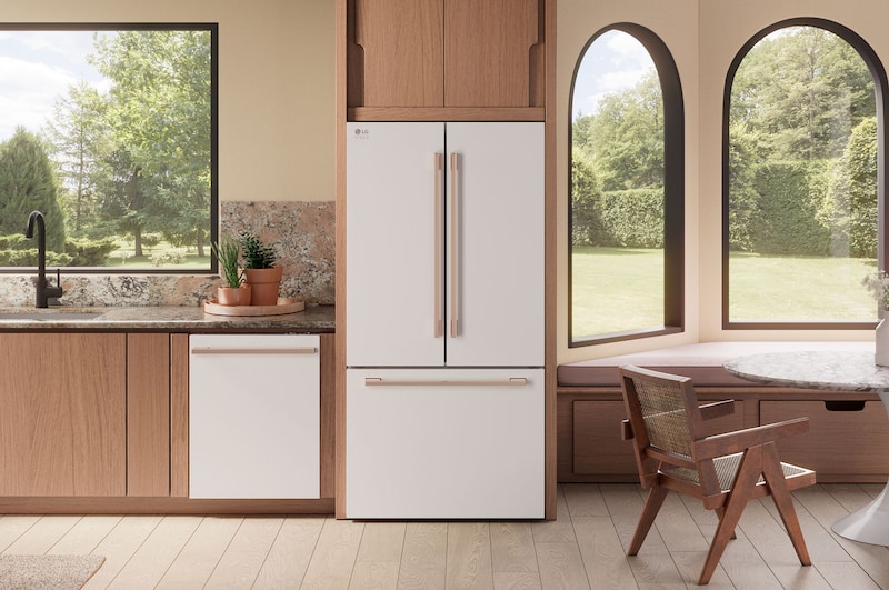 The white finish LG STUDIO 36-inch 27 cu.ft. French Door Refrigerator SRFB27W3 with bronze handles, shown installed in a colorful modern kitchen.