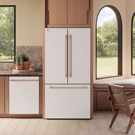 The white finish LG STUDIO 36-inch 27 cu.ft. French Door Refrigerator SRFB27W3 with bronze handles, shown installed in a colorful modern kitchen.