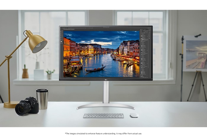 The LG Monitor 32UP83AK in a silver/black finish, featuring 4K UHD resolution and precise colour representation, is shown handling professional photo editing in a bright studio setting.