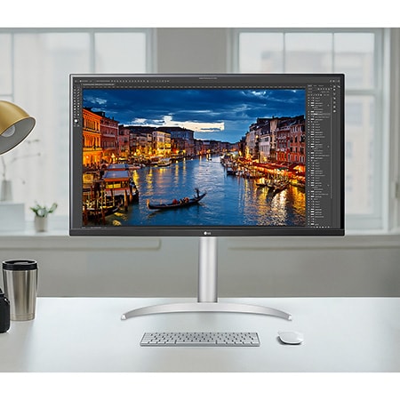 The LG Monitor 32UP83AK in a silver/black finish, featuring 4K UHD resolution and precise colour representation, is shown handling professional photo editing in a bright studio setting.