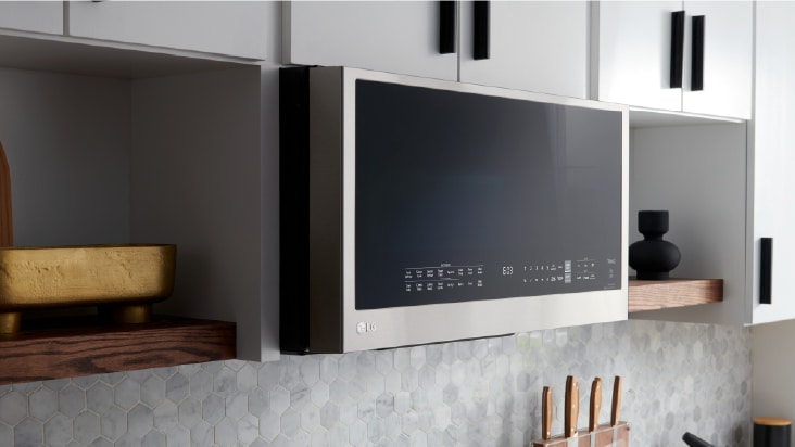 A silver LG countertop microwave with a glass door and right-side dial sits on a gray kitchen counter.