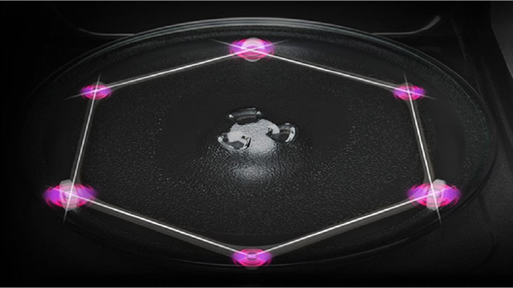 Overhead view shows a round glass turntable with three rings on a dark microwave base.