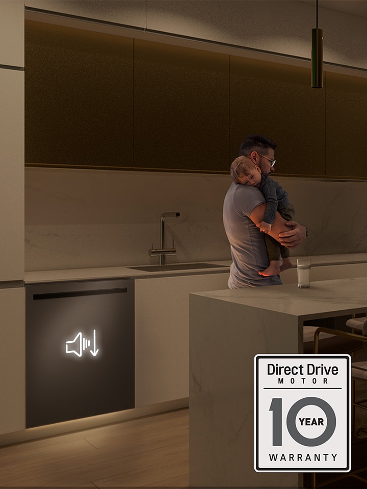 A man holding a sleeping child in a quiet kitchen with a stainless steel dishwasher featuring a low-noise icon.