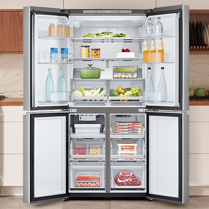 Open four-door stainless steel refrigerator stocked with food and drinks in a modern kitchen setting.