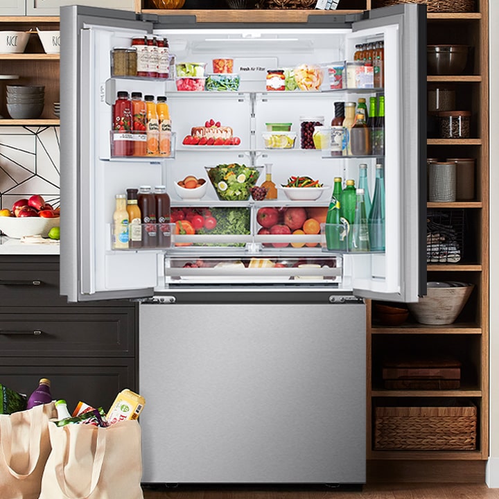 LG stainless steel French door refrigerator with external water dispenser and open doors showing a bright, spacious interior.