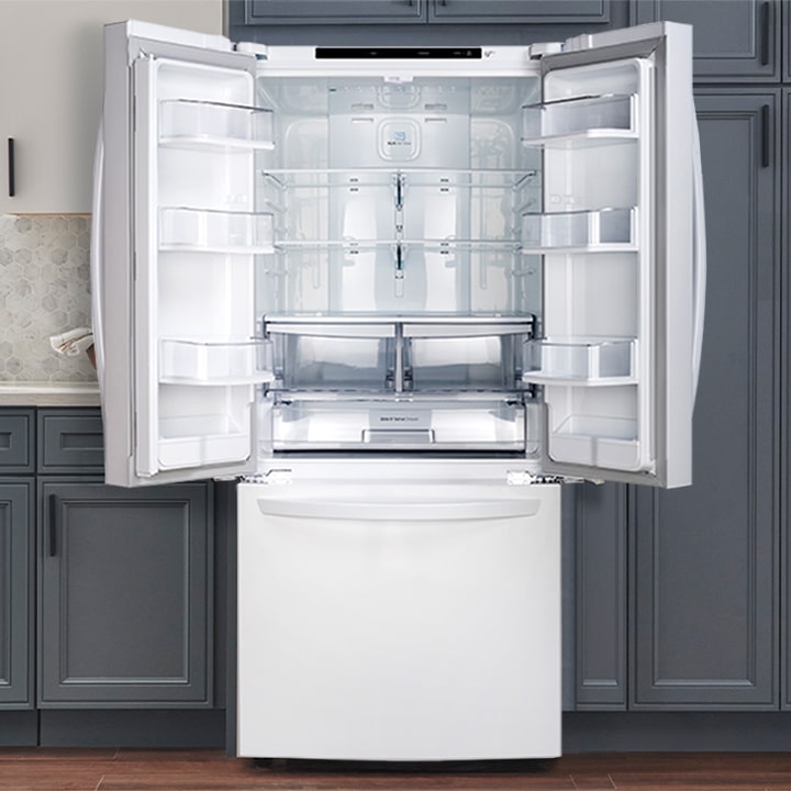 White French door refrigerator with open doors showing glass shelves, crisper drawers, and door bins in a kitchen.
