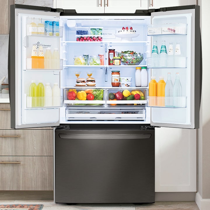 Open black stainless steel French door refrigerator stocked with fresh food and drinks in a modern kitchen.