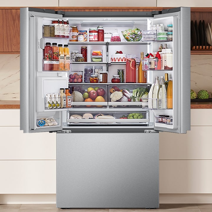 Open stainless steel French door refrigerator stocked with food, highlighting the spacious interior and organized shelves.