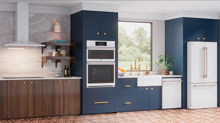 Modern kitchen with white LG appliances, navy blue and wood cabinets, gold hardware, and patterned tile flooring.