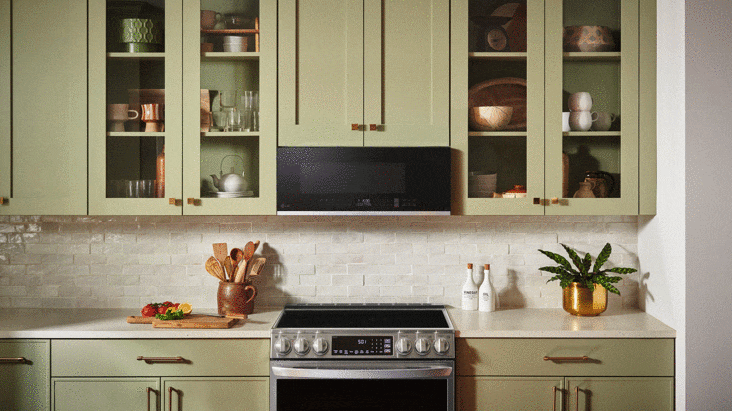 Interior of a stainless steel over-the-range microwave with bright LED lighting illuminating a glass turntable.