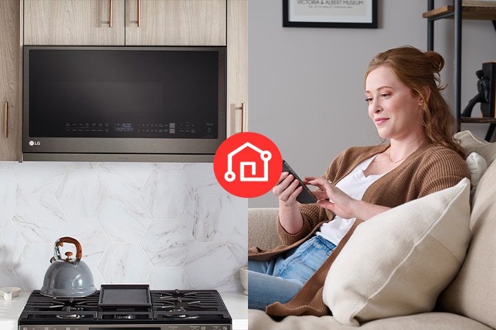 A woman uses a smartphone to remotely control a black stainless steel LG over-the-range microwave.