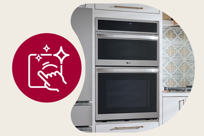 Close-up of a hand wiping a smudge-resistant stainless steel LG double wall oven with a microfiber cloth.