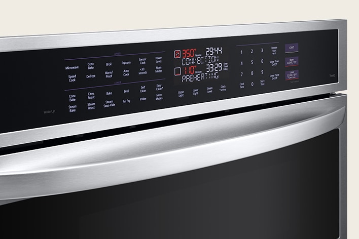 Close-up of a stainless steel wall oven's SmoothTouch glass control panel with digital display and touch buttons.