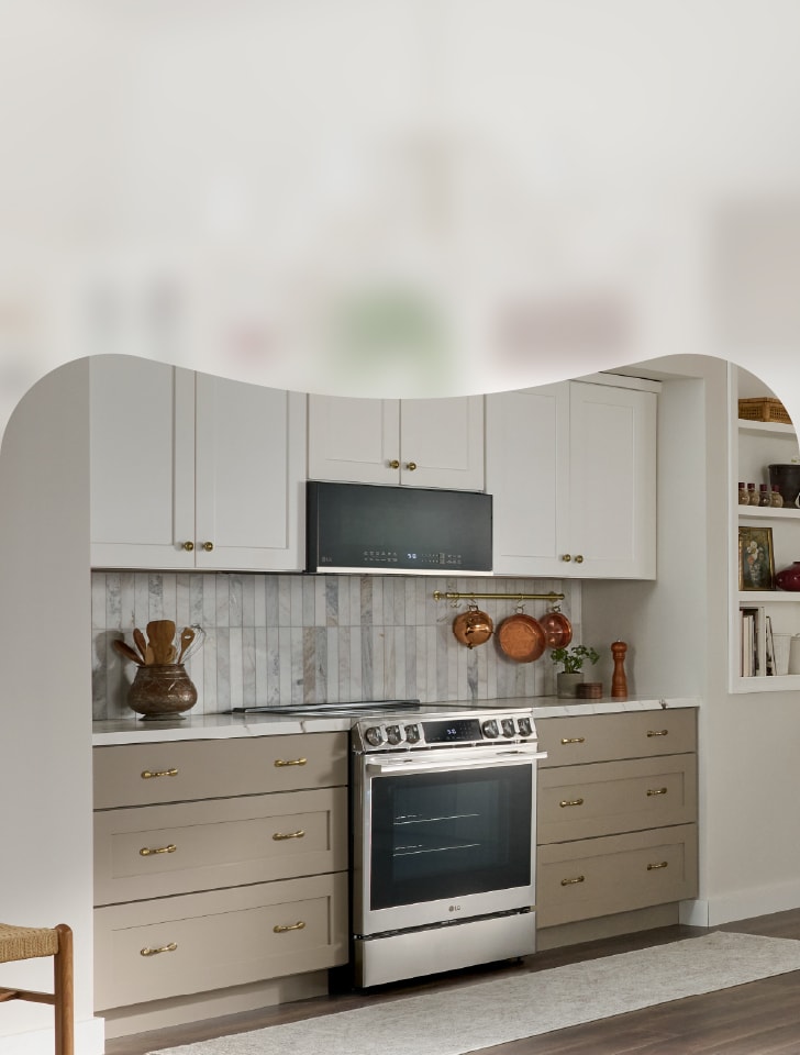 Beige-and-white kitchen with an LG range and microwave and copper pots.