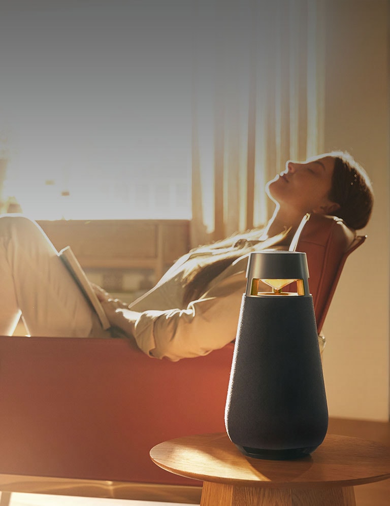 A woman is listening to music while sitting on a sofa.