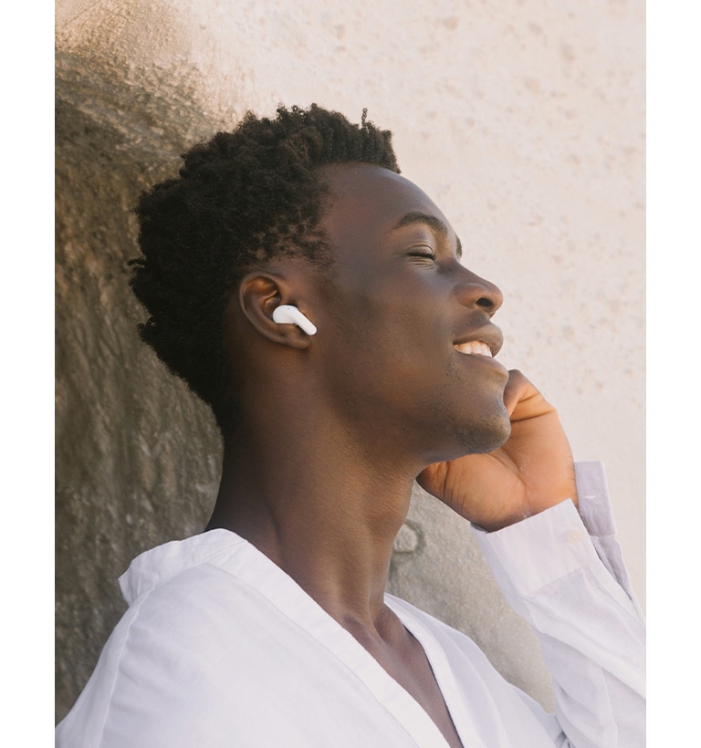 A man is wearing T90 earbuds and listening to music with his eyes closed.