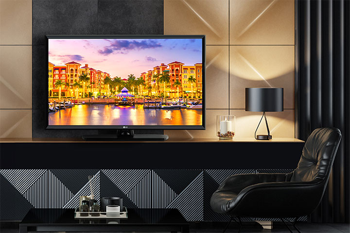 A TV is installed in the hotel room, and a vivid sunset scenery is displayed on the screen.
