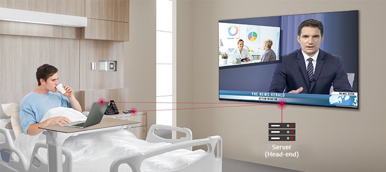 The patient lying on the bed connect his laptop wirelessly to the TV through the "virtual" Wi-Fi feature.