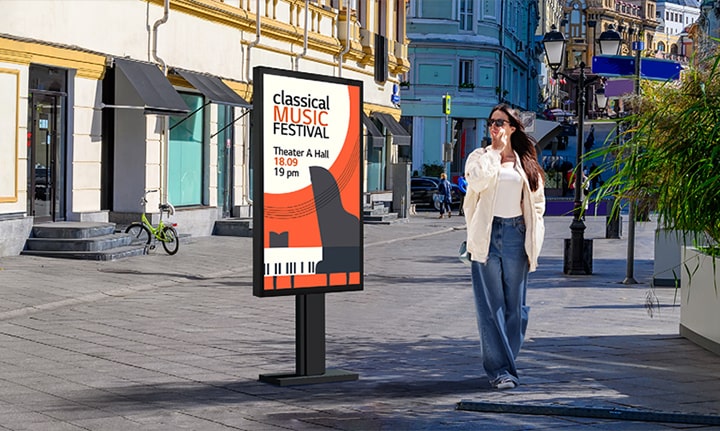 An XE3P is installed on the street, and a woman is looking at a vivid-quality advertisement on the screen.	