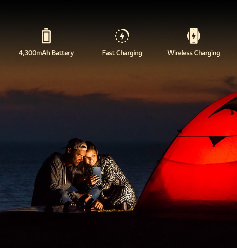 A couple in front of tent at night.