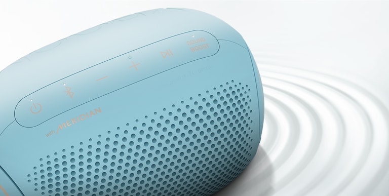 A top view of an LG XBOOM Go PL2B on a white surface with a ripple effect