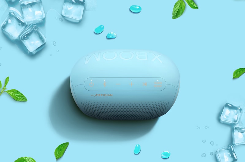 Watermelons, jellybeans, and an LG XBOOM Go PL2B are placed on a green background.