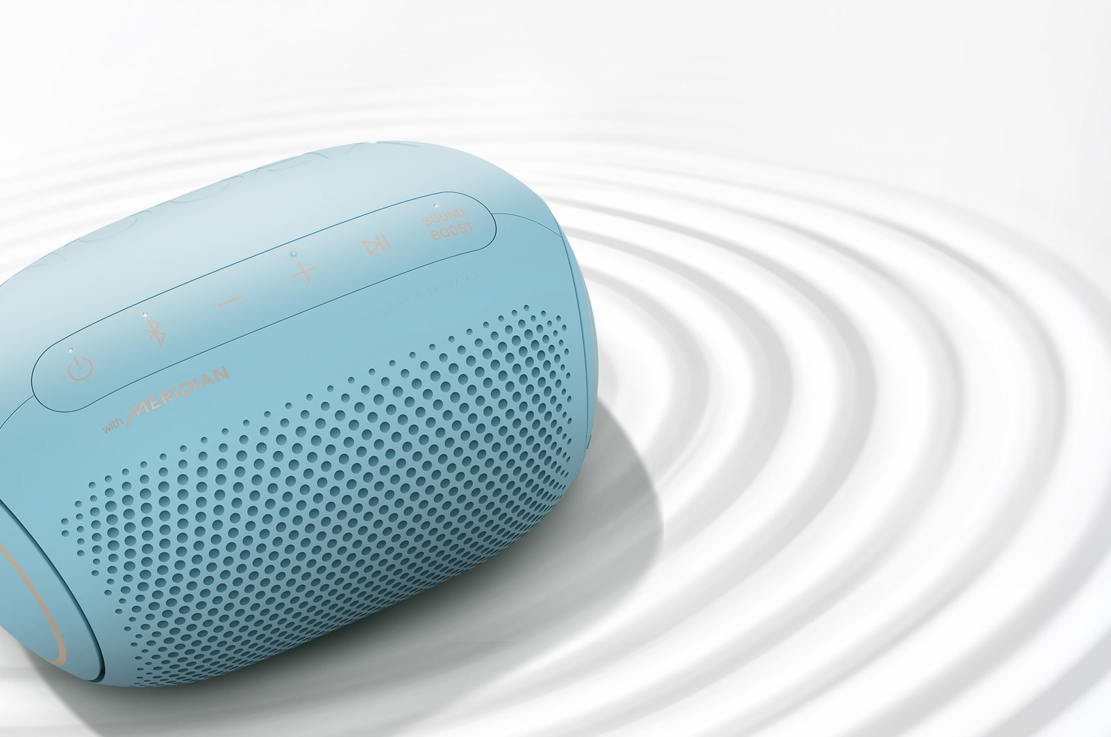 A top view of an LG XBOOM Go on a white surface with a ripple effect