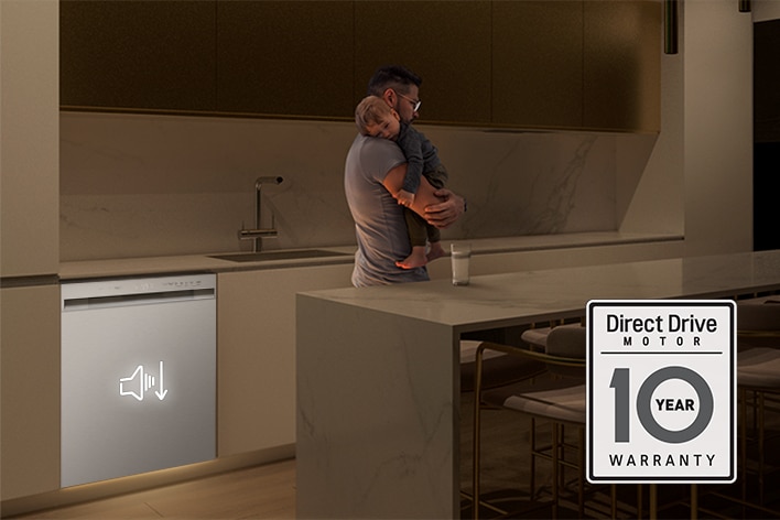 A man holding a sleeping child in a quiet kitchen next to a dishwasher with an Inverter Direct Drive motor icon.